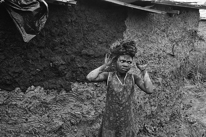 Carrying mud to plaster newly built home. Amouti