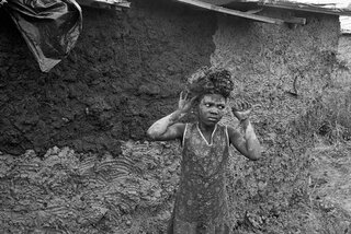 Carrying mud to plaster newly built home. Amouti